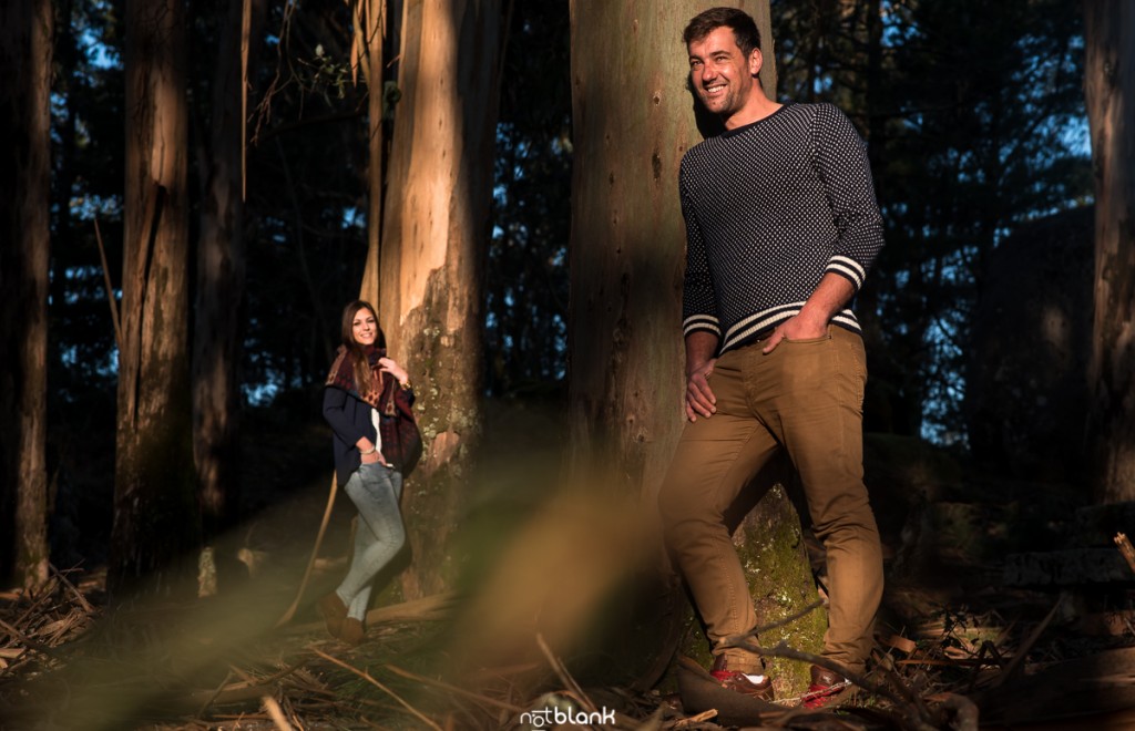 Sesión preboda en picoña. Retrato del novio apoyado sobre un árbol y la novia al fondo. Reportaje realizado por los fotógrafos de boda en Vigo Notblank.