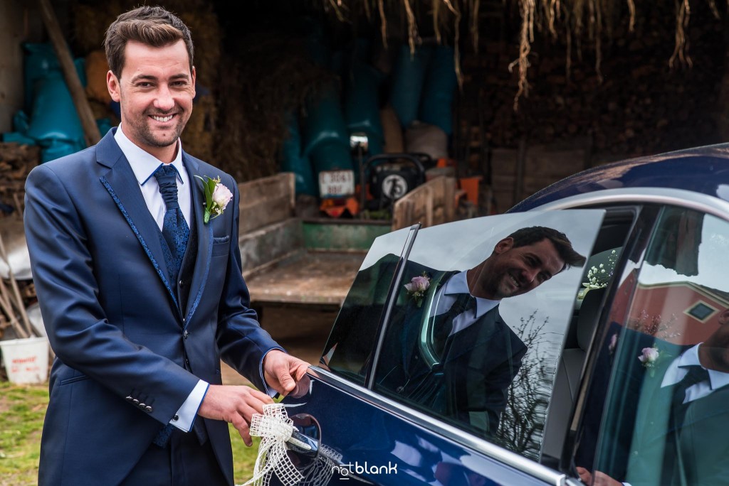 Boda en Salceda de Caselas. El novio se sube a un BMW azul para ir a la ceremonia. Reportaje realizado por Notblank fotógrafos de boda en Galicia.