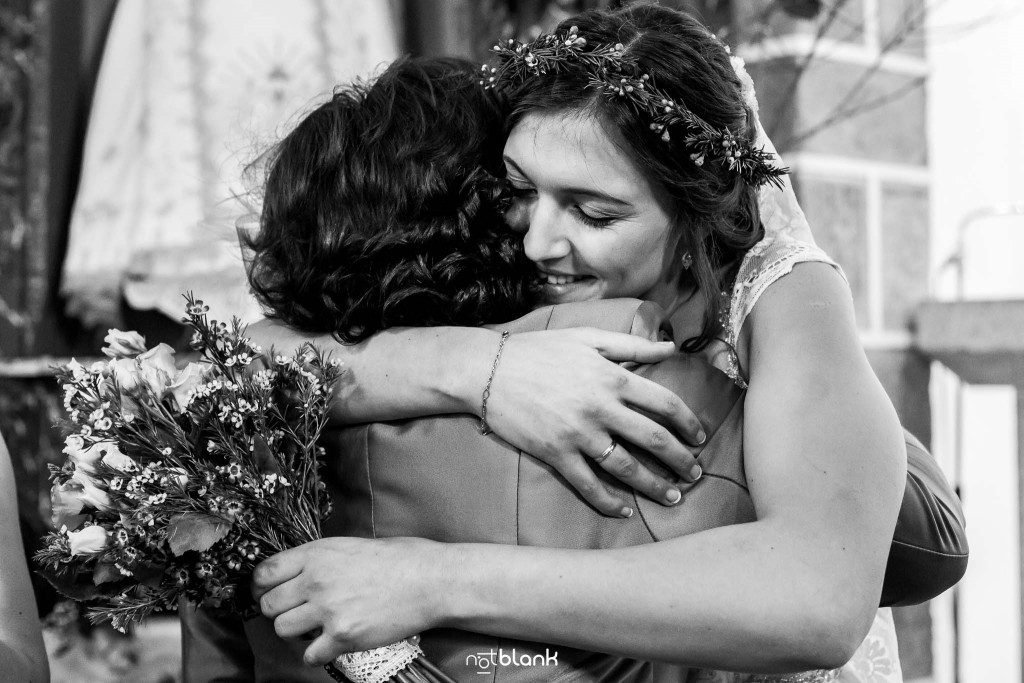 Boda en Salceda de Caselas. La madre de la novia felicita y abraza a su hija en la iglesia. Reportaje realizado por Notblank fotógrafos de boda en Galicia.