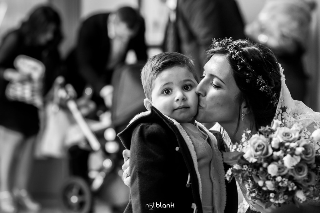 Boda en Salceda de Caselas. La novia le da un beso a su sobrino. Reportaje realizado por Notblank fotógrafos de boda en Galicia.