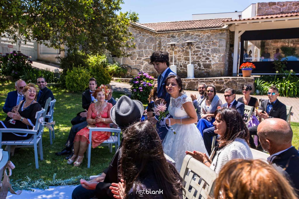 Boda en Quinta San Amaro en Meaño. Los invitados reciben a la novia que viene de brazo de su sobrino. Reportaje realizado por Notblank fotógrafos de boda en Cangas.