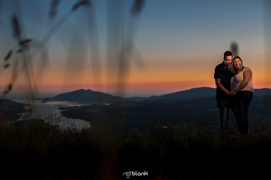 Preboda internacional en Valença do Minho. Retrato de los novios con la puesta de sol al fondo y la desembocadura del Río Miño. Reportaje de sesión preboda realizado por Notblank fotógrafos de boda en Galicia.