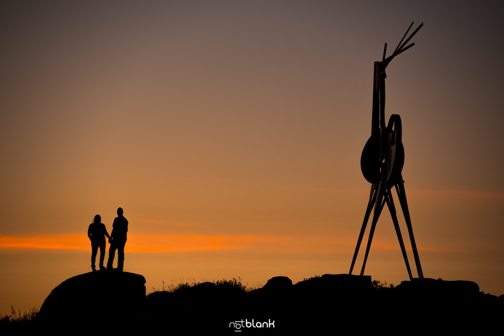 Preboda internacional en Valença do Minho. Silueta de los novios y la famosa escultura de El Ciervo en Vila Nova de Cerveira al atardecer. Reportaje de sesión preboda realizado por Notblank fotógrafos de boda en Galicia.