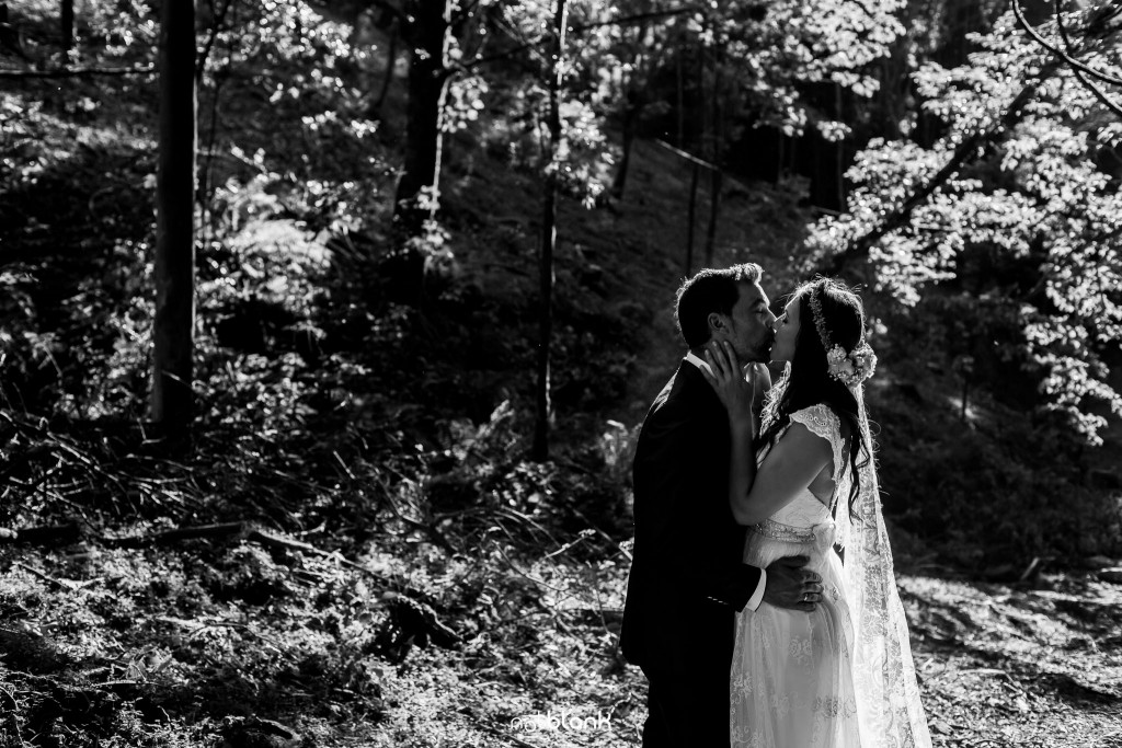 Sesión Postboda en Portugal. La pareja se besa apasionadamente en el bosque. Reportaje realizado por Notblank fotógrafos de boda en Galicia.