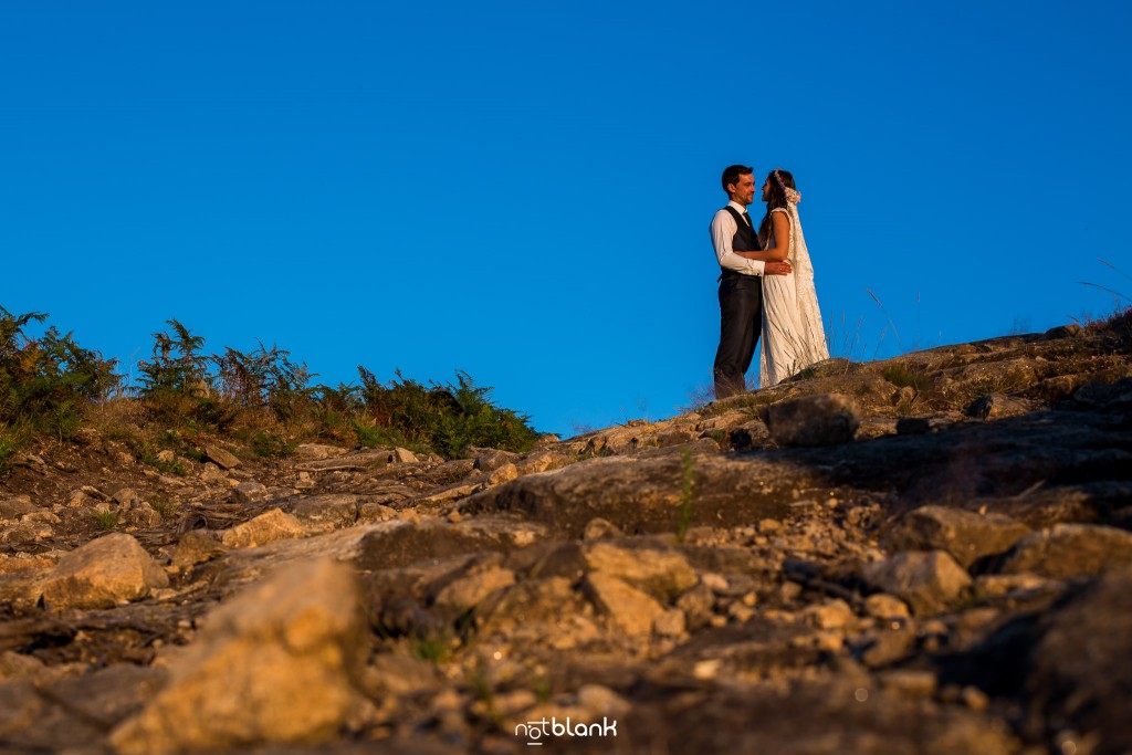 Sesión Postboda en Portugal. La pareja se abraza en la montaña con el sol del atardecer. Reportaje realizado por Notblank fotógrafos de boda en Galicia.