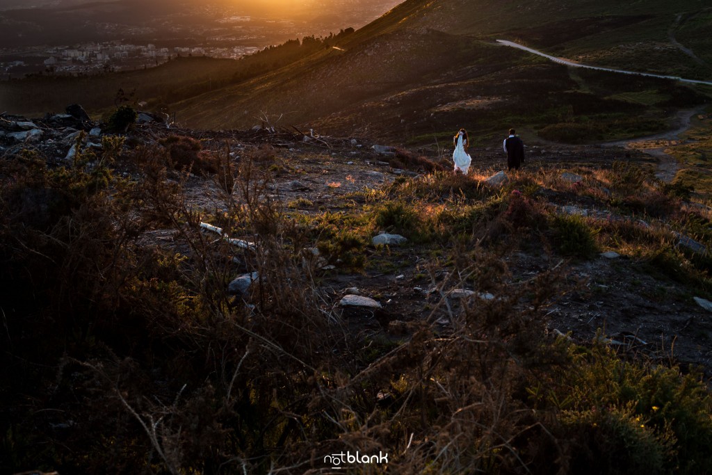 Sesión Postboda en Portugal. La pareja camina en la montaña hacia la puesta de sol del atardecer. Reportaje realizado por Notblank fotógrafos de boda en Galicia.