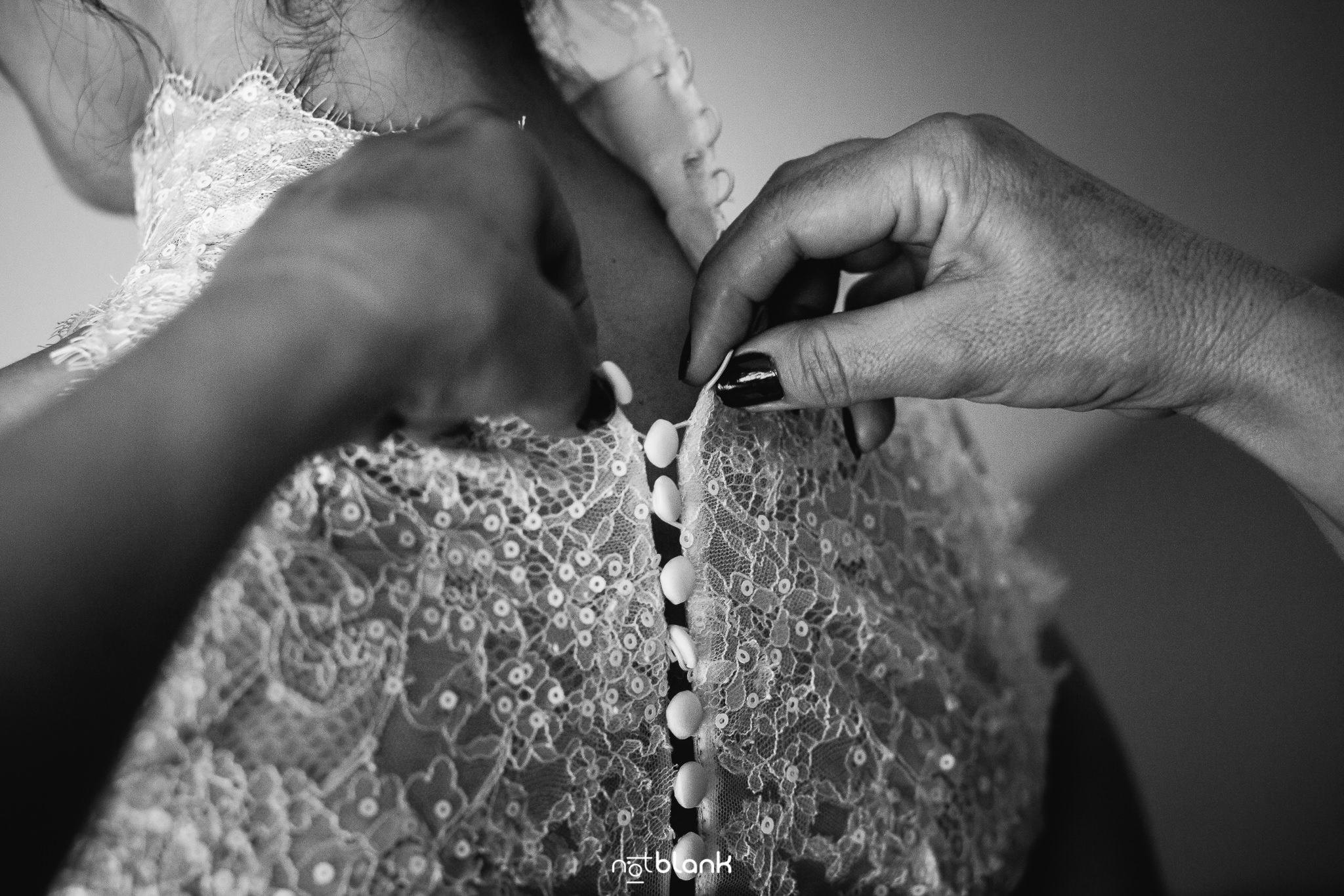 Boda-Maite-David-Preparativos-Novia-Amiga-Abrochando-Botones-Vestido. Reportaje realizado por Notblank fotógrafos de boda