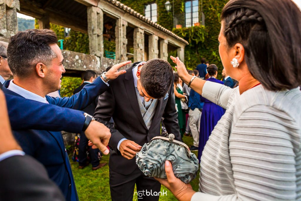 Los amigos del novio le ayudan a sacarse los pétalos del traje